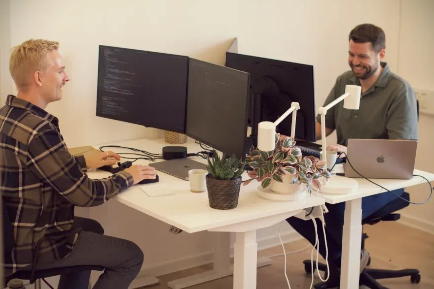 Two of the PineGrove founders working at their desks in the office